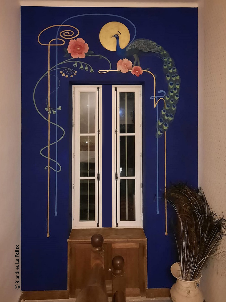 Décor peint dans une cage d'escalier, représentant un paon, des fleurs et des ornementations d'inspiration art nouveau avec filets verts, bleus et pigments d'or, sur fond bleu outremer.