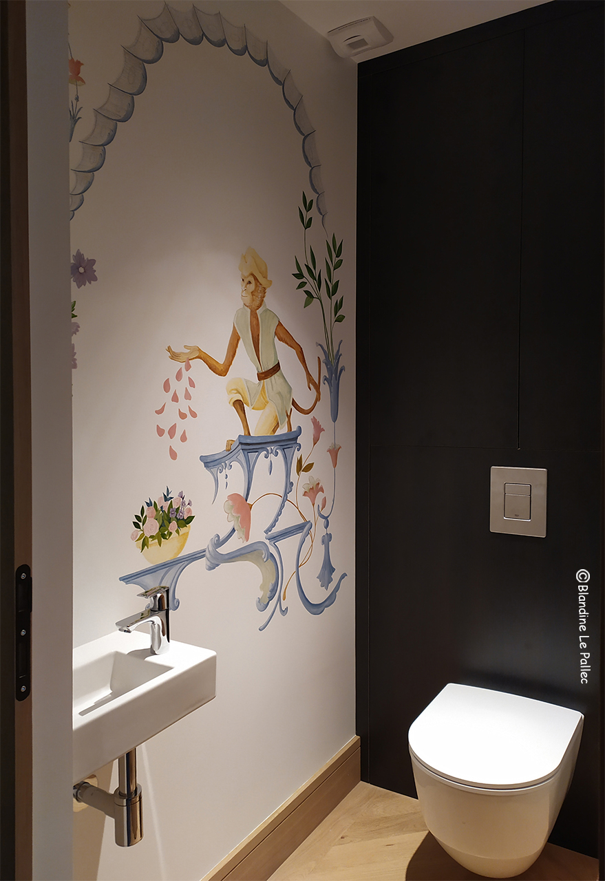 Décor peint dans des toilettes, représentant un singe habillé qui lance des pétales de roses. Décor qui s'inspire des singeries et ornementations du 18me siècle